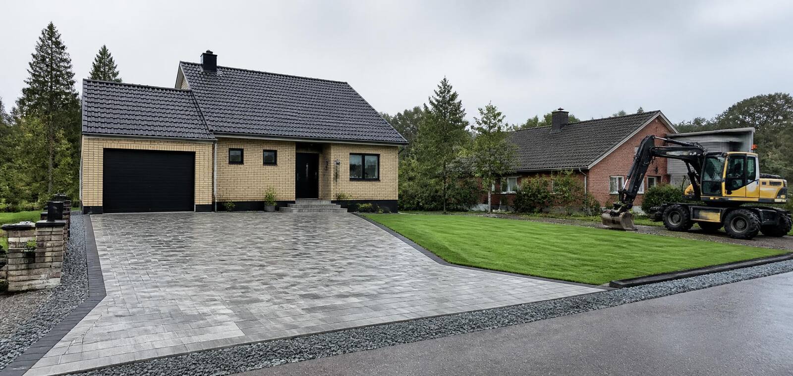 Färdig uppfart med plattor, grusad kant och nylagd gräsmatta
